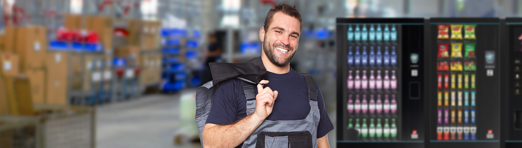 Industrie Ein Mann in Arbeitsklamotten vor drei Automaten