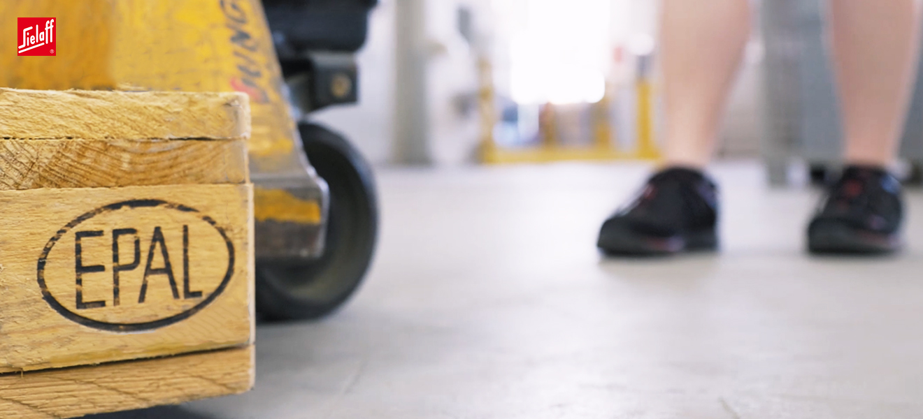 Eine Fachkraft für Lagerlogistik mit einem Hubwagen