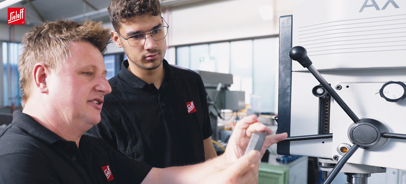 Zwei Industriemechaniker an einer Maschine