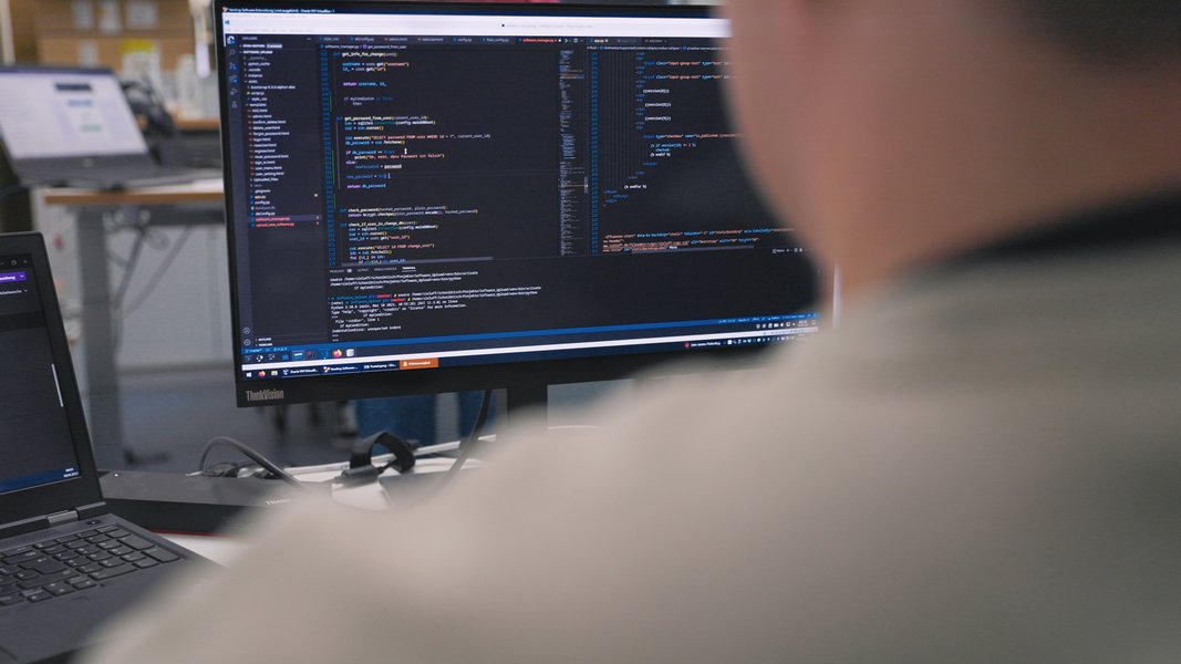 Ein Fachinformatiker für Anwendungsentwicklung vor Bildschirmen