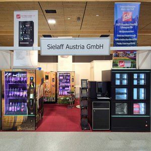 Messestand von Sielaff Austria GmbH mit mehreren Getränkeautomaten und Informationsständen auf rotem Teppichboden in einer Messehalle.